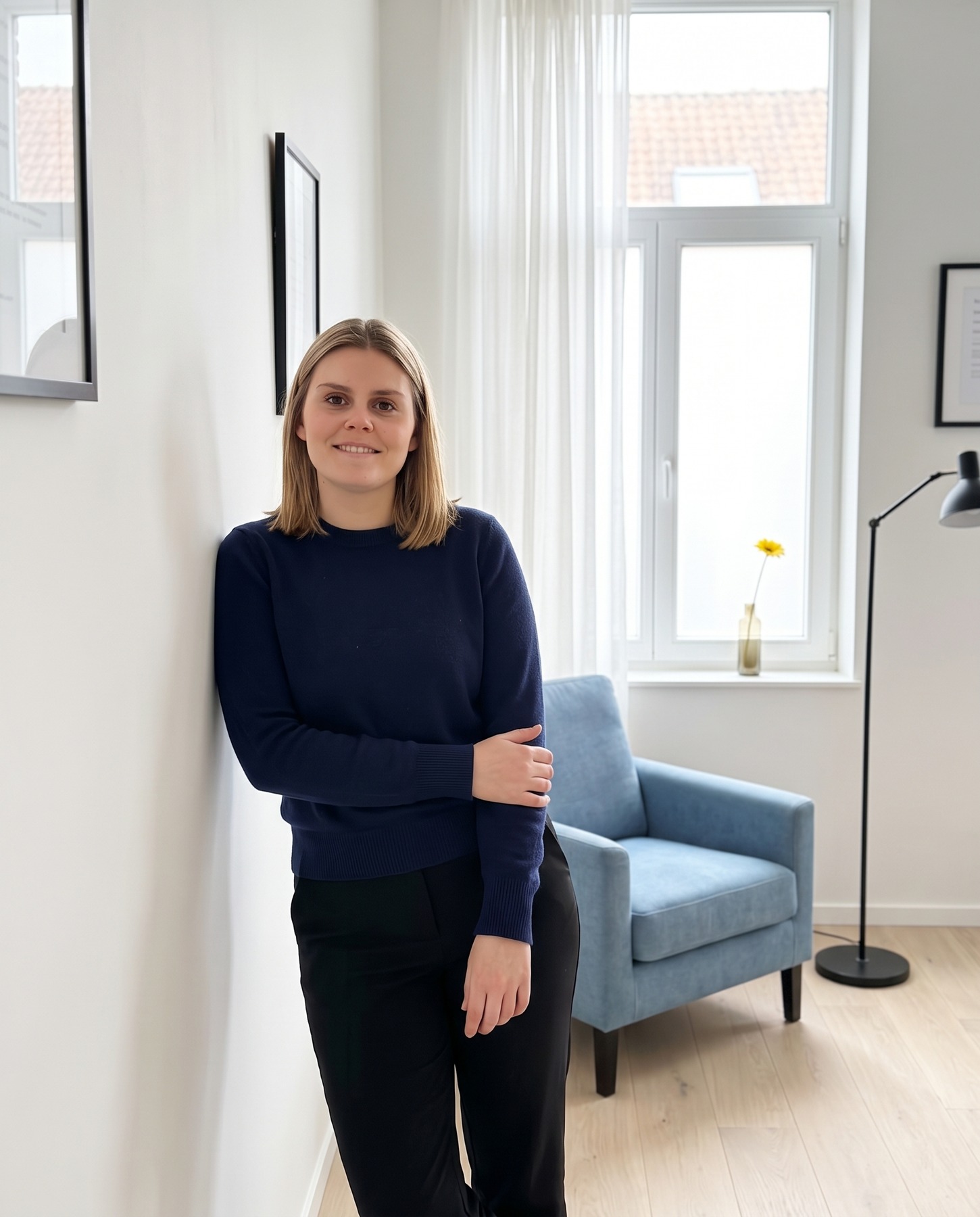Louise leunt tegen de muur in haar praktijk